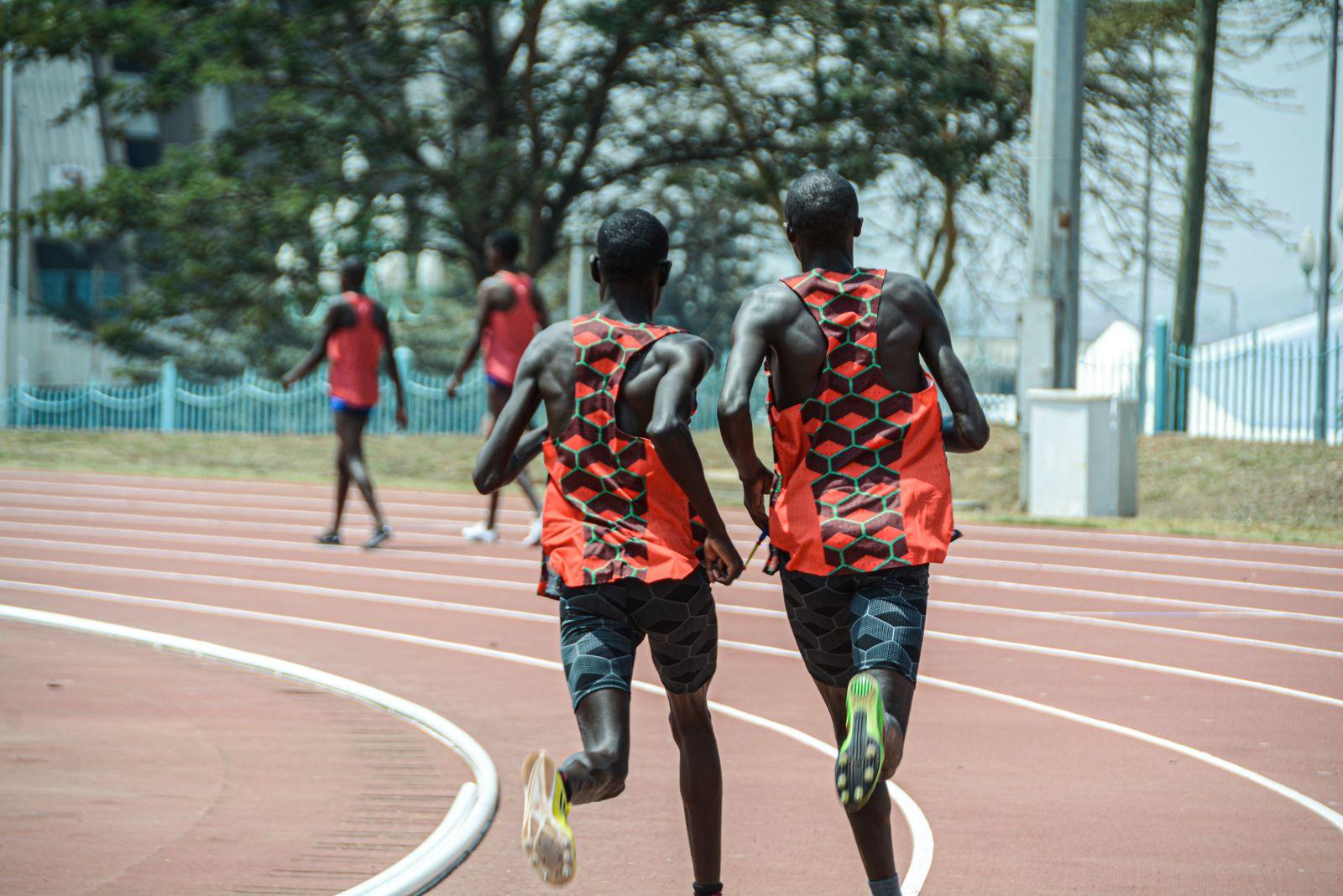 Two developing distance runners training together on a track in Nairobi